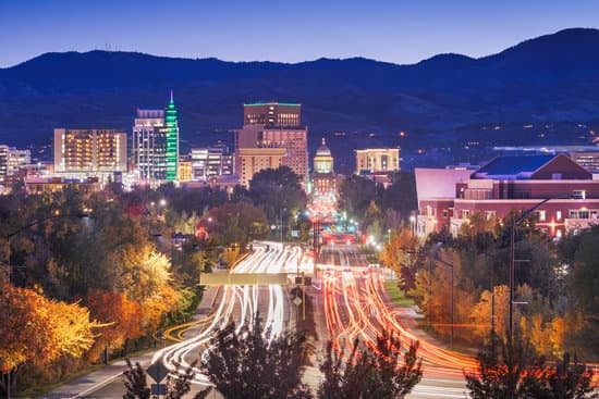 Nighttime cityscape with illuminated buildings and busy roads.